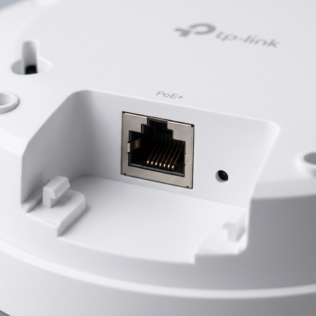 Close-up of the rear Gigabit PoE+ Ethernet port and reset pinhole on a white TP-Link access point.